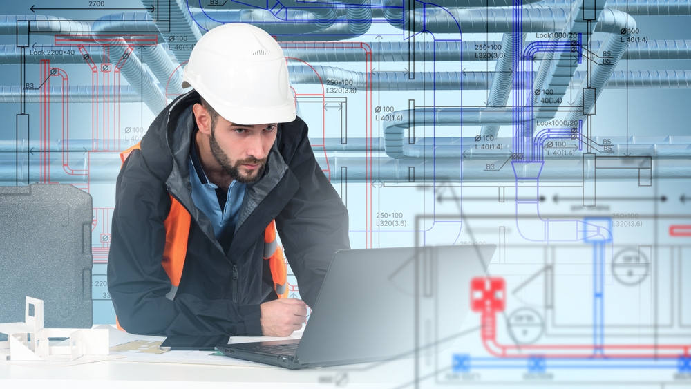 Engineer analyzing technical blueprints on a laptop for a custom pneumatic conveying system design